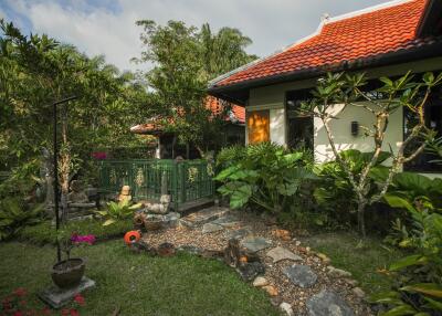 Lush garden with a stone path leading to a house