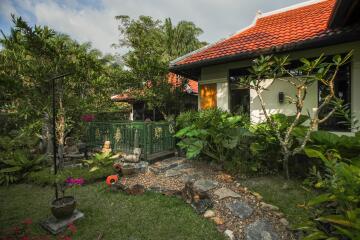 Lush garden with a stone path leading to a house