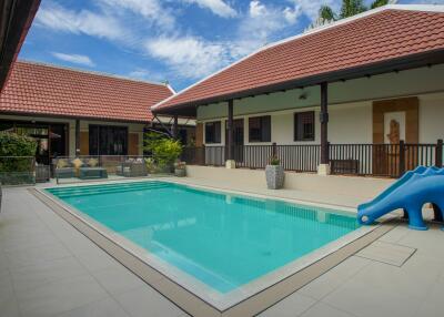 Outdoor pool area with surrounding buildings and a slide