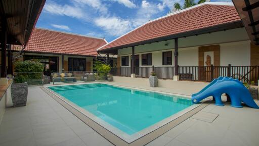 Outdoor pool area with surrounding buildings and a slide