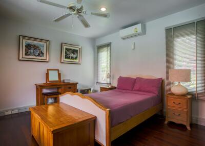 Cozy bedroom with wooden furniture and purple bedspread