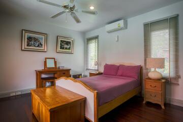 Cozy bedroom with wooden furniture and purple bedspread