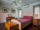 Cozy bedroom with wooden furniture and purple bedspread