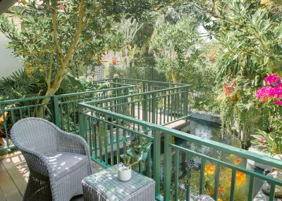 Cozy balcony with wicker furniture and lush garden view