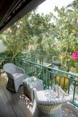 Cozy balcony with wicker furniture and lush garden view