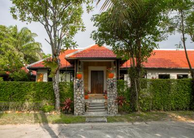 Front view of the house with a red roof and stone pillars