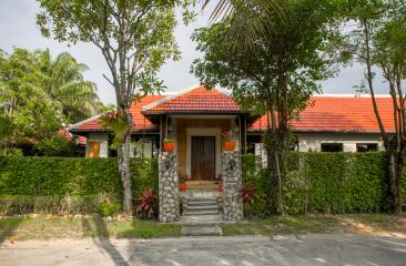 Front view of the house with a red roof and stone pillars