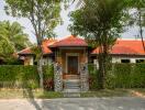 Front view of the house with a red roof and stone pillars