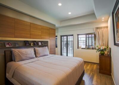 Cozy bedroom with large bed, wooden flooring, and well-lit space