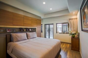 Cozy bedroom with large bed, wooden flooring, and well-lit space