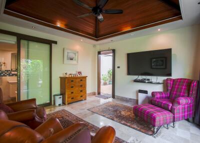 Spacious living room with wooden ceiling, modern furniture, and large TV