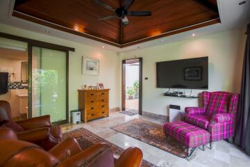 Spacious living room with wooden ceiling, modern furniture, and large TV