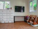 Bedroom with dresser, wall-mounted TV, and children's chairs