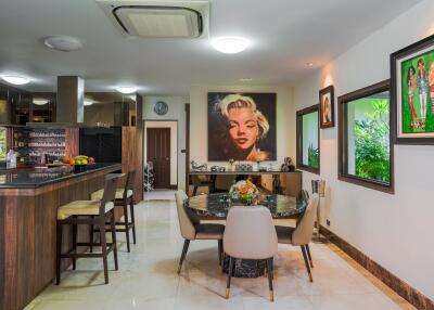 A modern kitchen and dining area with artwork on the walls