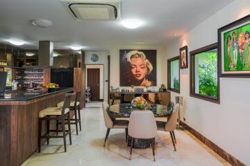 A modern kitchen and dining area with artwork on the walls