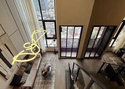 Modern living room with large windows, city view, and stylish decor