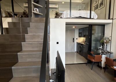 Modern duplex living area with lofted bedroom and open stairway