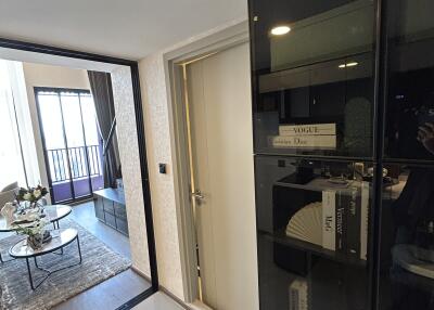 Entryway into a modern living room with a glass cabinet