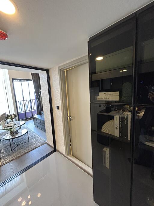 Entryway into a modern living room with a glass cabinet