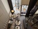 Aerial view of a modern living room with large windows, stylish furniture, and a chandelier