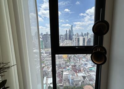 View from a window in a high-rise apartment overlooking a city skyline