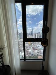 View from a window in a high-rise apartment overlooking a city skyline