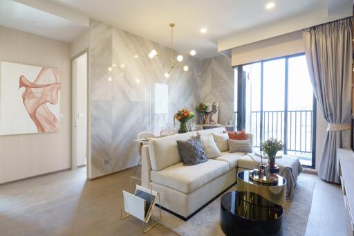 Modern living room with a cozy sofa, coffee table, abstract wall art, and large windows letting in natural light