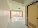 Vacant living room with tiled flooring and balcony access