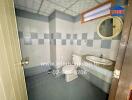 Bathroom with tiled walls and floor, toilet, and sink with mirror