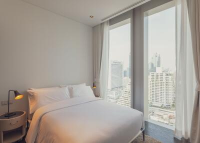 Modern bedroom with large windows and city view