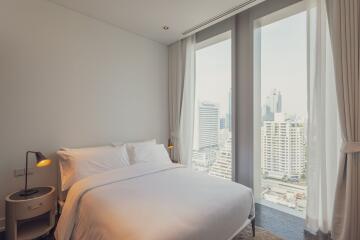 Modern bedroom with large windows and city view