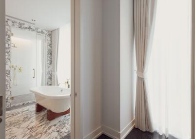 Bright marble bathroom with freestanding tub and large window