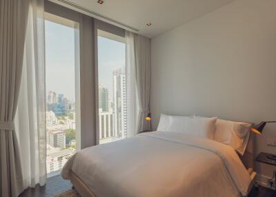 Modern bedroom with large windows offering a city view