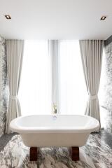 Luxurious bathroom with freestanding bathtub and marble walls