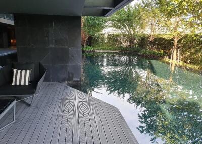 Modern outdoor pool area with seating and greenery