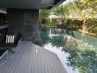 Modern outdoor pool area with seating and greenery