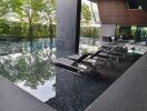 Luxury swimming pool area with lounge chairs and greenery