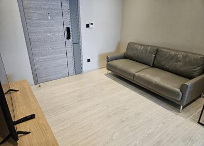 Living room with gray couch and light wood flooring