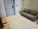 Living room with gray couch and light wood flooring