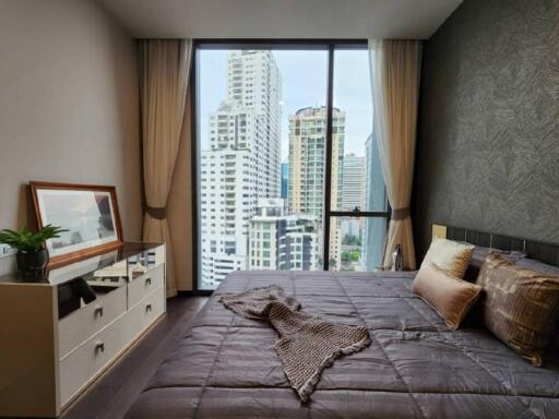 Bedroom with large glass window and city view