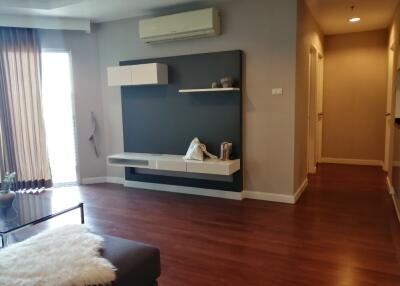 Living room with wall-mounted shelves and air conditioner