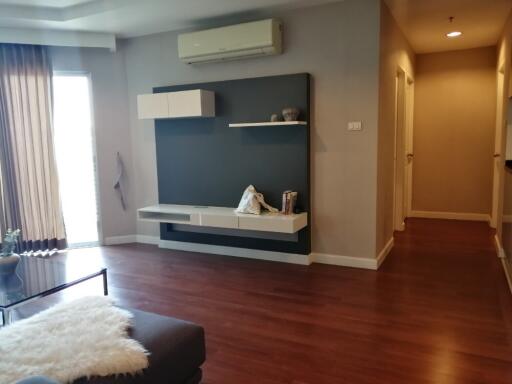 Living room with wall-mounted shelves and air conditioner