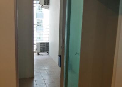 View of a hallway with a sliding glass door, leading to a balcony area with tiled flooring