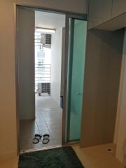 View of a hallway with a sliding glass door, leading to a balcony area with tiled flooring