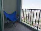 Balcony with a view of high-rise buildings and a blue folding chair