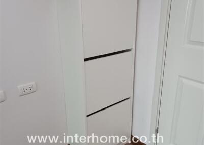 Corner of a room with a white cabinet and door