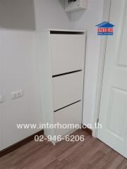 Corner of a room with a white cabinet and door