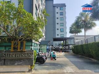 Condominium building exterior with entrance and parked motorbikes