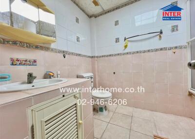 Spacious bathroom with sink, toilet, and tiled walls