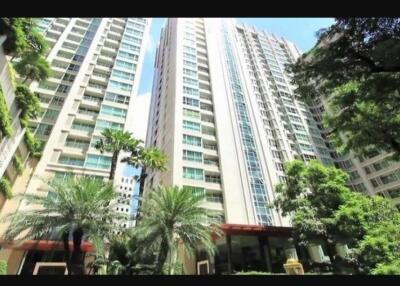 High-rise condominium buildings surrounded by lush greenery